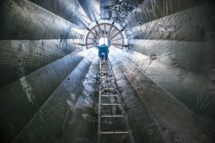 Wind Turbine Technician student climbing inside the monopole at Pinnacle Career Institute